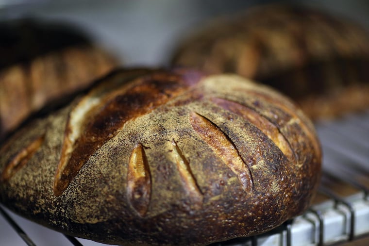 Loaves of Miche bread cool inside Metropolitan Bakery in Fishtown. (DAVID MAIALETTI / Staff Photographer )