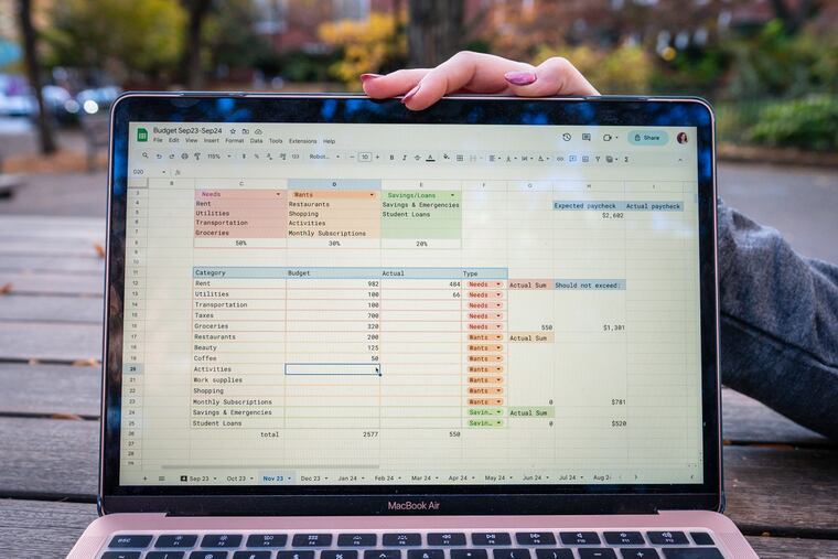 Abby Bailey, an occupational therapist who sells her budgeting templates on Etsy as a "side hustle," displays her spreadsheets in Kahn Park in Philadelphia, Wednesday, Nov. 8, 2023.