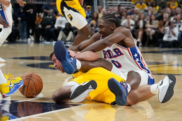 Sixers guard Tyrese Maxey (0) scraps for a loose ball with former Sixer T.J. McConnell of the Pacers. 