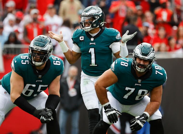 Eagles quarterback Jalen Hurts with tackle Lane Johnson (left)  and guard Sua Opeta during the NFC wild-card playoff game against the Tampa Bay Buccaneers in January 2022. 