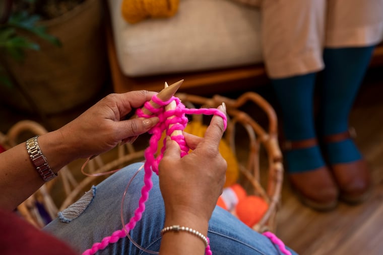 (left) Yolanda Booker and Liz Sytsma demonstrate how to knit a scarf at Sytsma's shop, Wild Hand, in the Mt. Airy neighborhood of Philadelphia, Pa. on Thursday, November 19, 2020. Wild Hand is "a neighborhood supply shop for fiber folk," according to their website. The shop has been open since April 2019, and offers materials and education for weaving, crochet, knitting, felting and more.