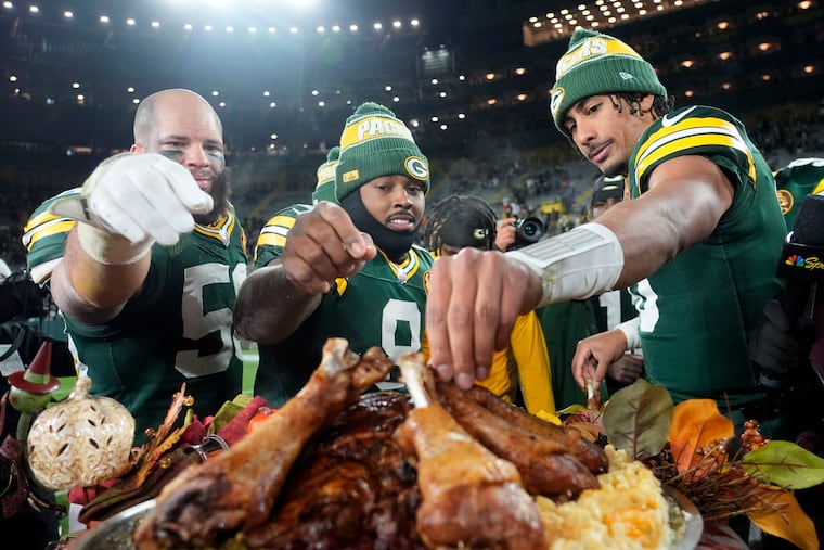 Green Bay Packers (from left) Isaiah McDuffie, Josh Jacobs, and Jordan Love eat turkey legs after beating the Miami Dolphins on Thanksgiving.