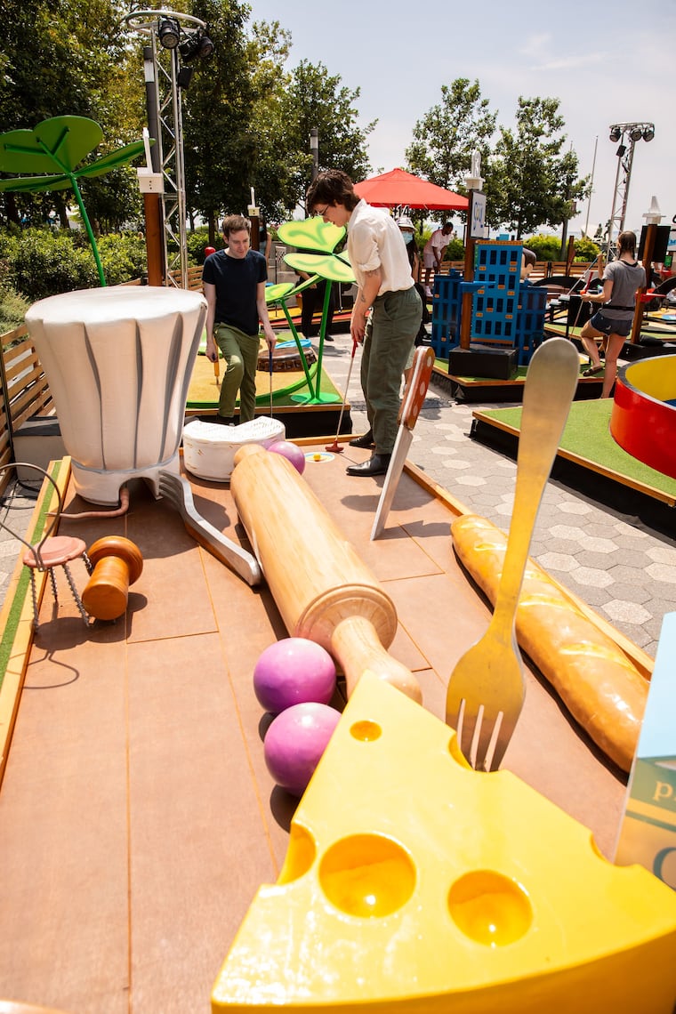 Mini-golfers try their skill at a "Ratatouille" inspired stop on the Pixar Putt course.