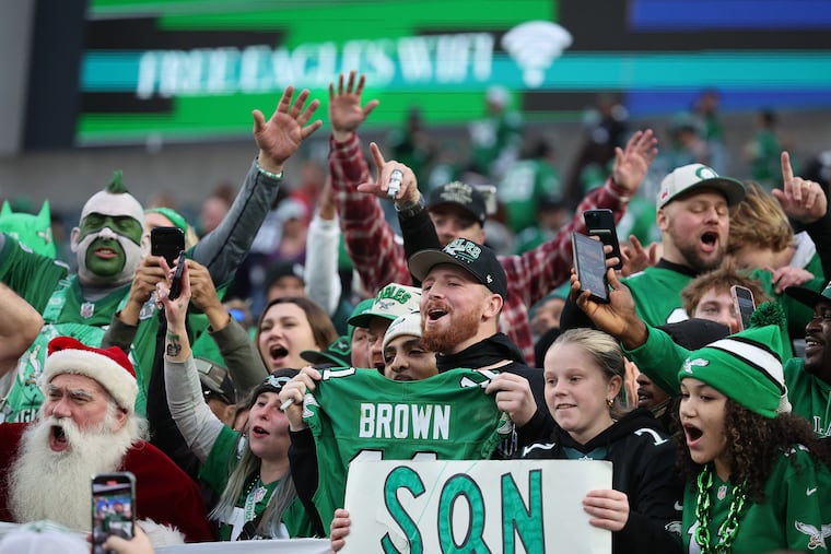 Eagles fans — including one who got A.J. Brown's game-worn jersey (center) — react as the players leave the field after beating the Dallas Cowboys.