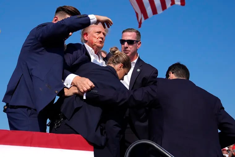 Former President Donald Trump is surround by U.S. Secret Service agents at a campaign rally, Saturday, July 13, 2024, in Butler, Pa.