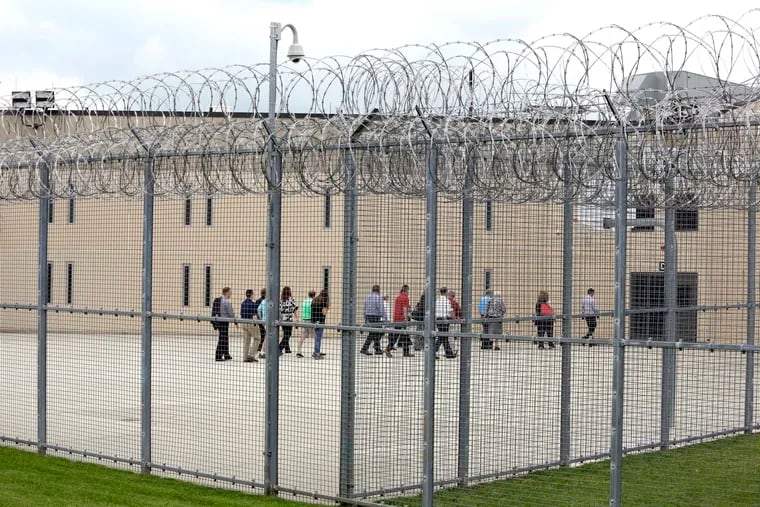 In this June 1, 2018, file photo, people walk on a tour of the west section of the State Correctional Institution at Phoenix in Collegeville, Pa.  (AP Photo/Jacqueline Larma)