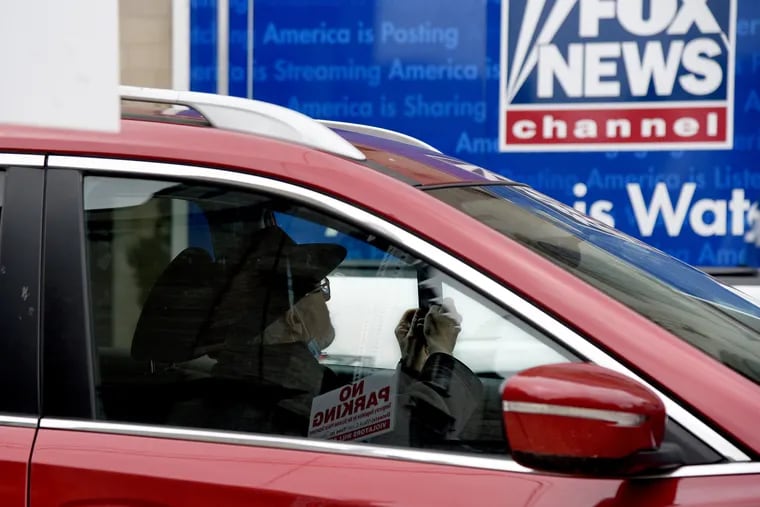 Trump supporter Jack McGovern, 67, pulls up in his car to take a picture of the Fox News tractor trailer parked outside the Scranton Cultural Center on March 4., the day before President Trump made his first visit of 2020 to the battleground state of Pennsylvania, for a Fox News town hall-style event at the former Masonic Temple and Scottish Rite Cathedral.