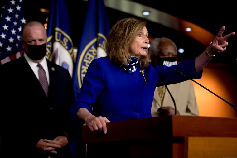 House Speaker Nancy Pelosi of Calif., accompanied by Rep. Dan Kildee, D-Mich., left, and Rep. Danny Davis, D-Ill., right, speaking at a news conference on Capitol Hill in Washington on Friday.