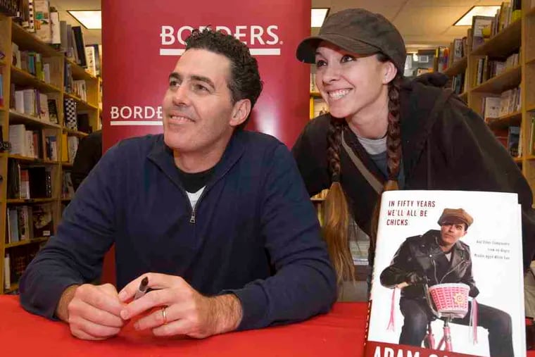 Comedian Adam Carolla poses with book buyer Katerina Perdue of Center City at Borders in Center City. He was there Thursday to sign copies of &quot;In Fifty Years We'll All Be Chicks,&quot; his new collection of &quot;complaints.&quot;