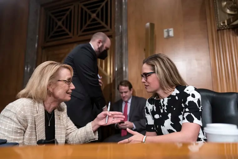 Sen. Maggie Hassan, D-N.H., left, speaks with Sen. Kyrsten Sinema, D-Ariz., during a meeting of the Senate Homeland Security Committee at the Capitol in Washington, Wednesday, Aug. 3, 2022.