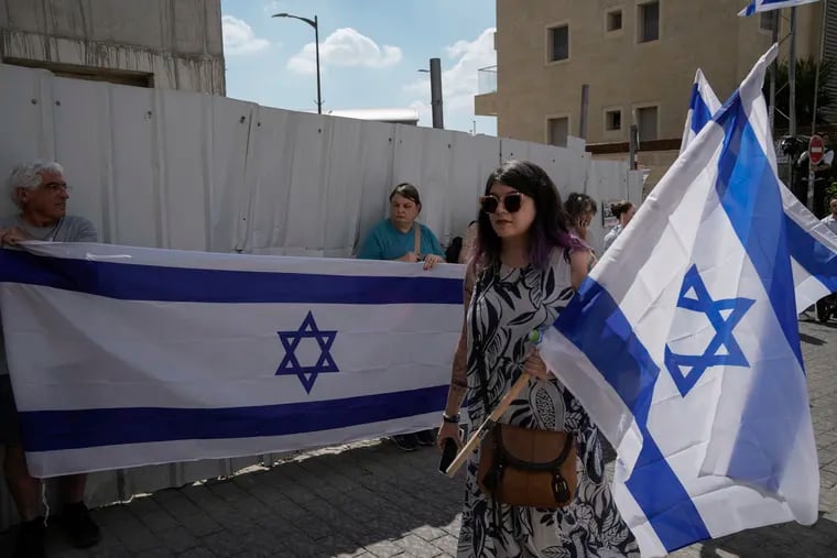 Mourners wave Israeli flags as they accompany the family of Israeli-American hostage Hersh Goldberg-Polin, who was killed in Hamas captivity in the Gaza Strip, on their way to his funeral in Jerusalem.