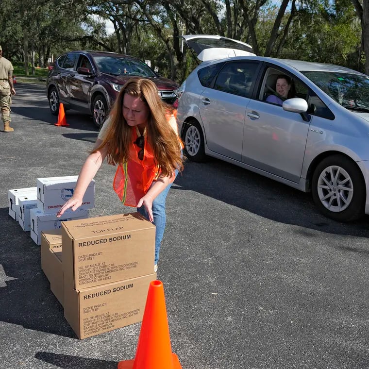 Hillsborough County employee Priscille Traugh helps load supplies into the cars of residents displaced by Hurricane Milton, Sunday, Oct. 13, 2024, at the Hillsborough Community College campus in Brandon, Fla. (AP Photo/Chris O'Meara)