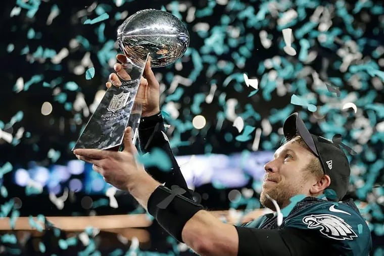Eagles quarterback Nick Foles lifts up the Vince Lombardi trophy after leading his team to a 41-33 victory over the Patriots in Super Bowl LII.