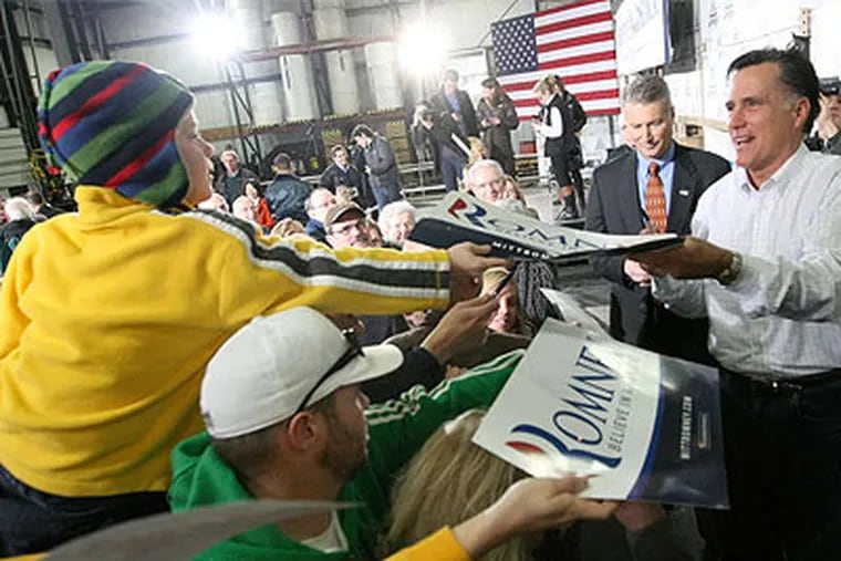 Former Massachusetts Gov. Mitt Romney signs an autograph for Gabe Roberts, 6, during a campaign stop in Dubuque. (Jessica Reilly / Telegraph Herald (Dubuque))