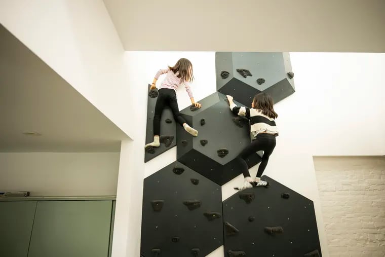 Ten-year-old twins Olivia (left) and Sonia climb their rock wall at home.