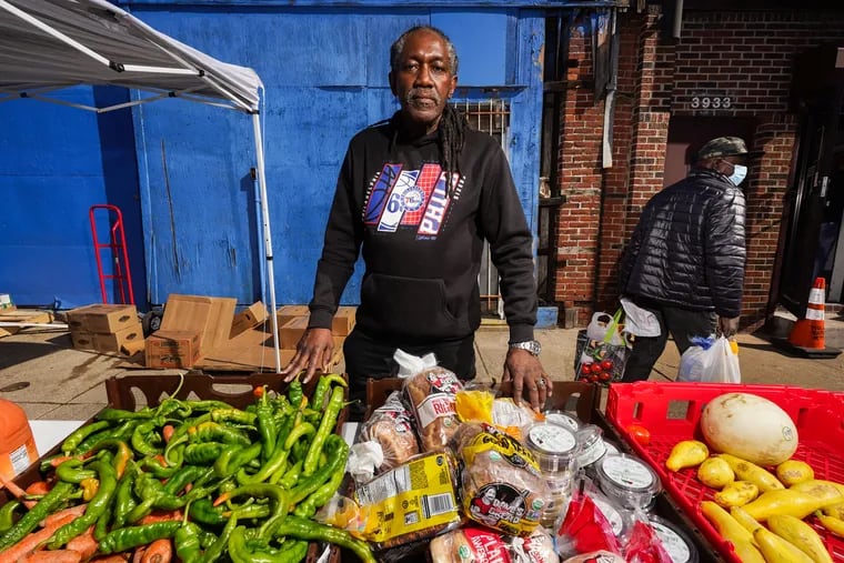 In a 2022 image, antiviolence advocate J. Jondhi Harrell works at a Philadelphia food bank, giving food to people in need.