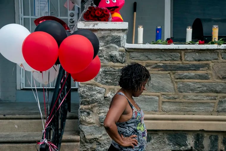A neighbor on North Simpson Street in West Philadelphia prepares for a candlelight vigil for 7-year-old Zamar Jones.
