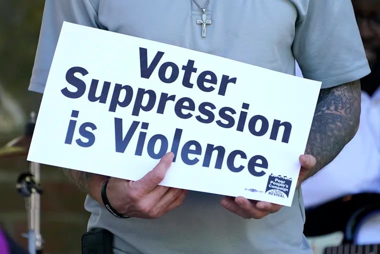 A person previously convicted of a felony holds a sign condemning voter suppression during a demonstration in Jackson, Miss., in April 2021. Roughly one out of every 59 adults — or slightly less than 2% of the voting-age population — is disenfranchised because of a felony conviction.