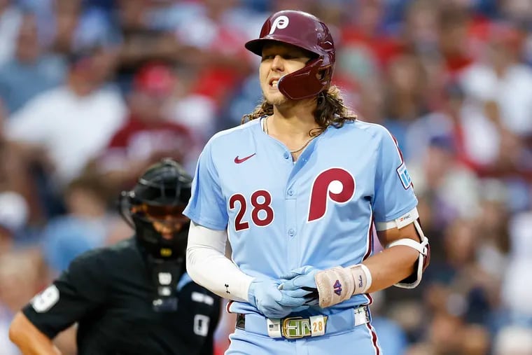 Phillies third baseman Alec Bohm holds his injured left hand during a game against the Braves on Aug. 29.