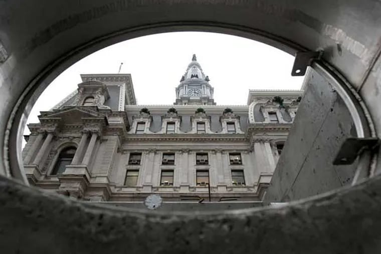 City Hall is seen through an opening leading to a reservoir for a fountain. (Charles Fox / Staff Photographer)