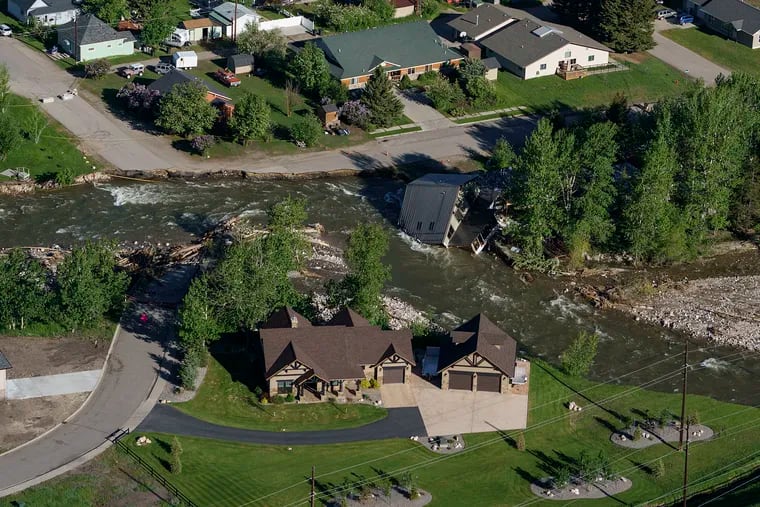 A house sits in Rock Creek on Thursday after floodwaters washed away a road and a bridge in Red Lodge, Mont.