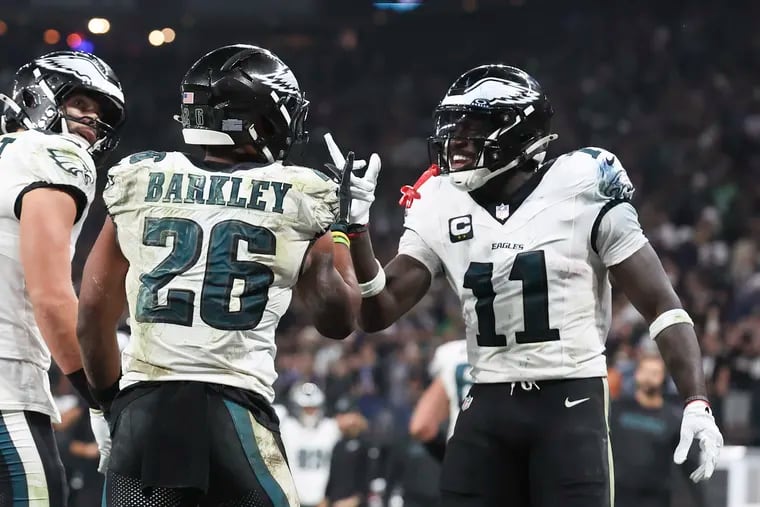 Eagles receiver A.J. Brown (right) congratulating Saquon Barkley during the opener. Brown will sit out Monday night with a hamstring injury.