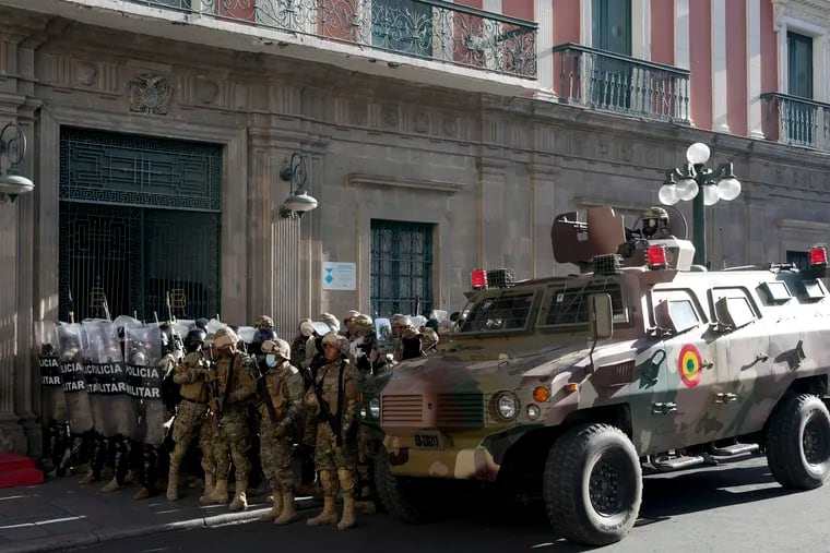 An armored vehicle and military police form outside the government palace at Plaza Murillo in La Paz, Bolivia, on Wednesday, June 26, 2024. Armored vehicles rammed into the doors of Bolivia's government palace Wednesday as President Luis Arce said the country faced an attempted coup.