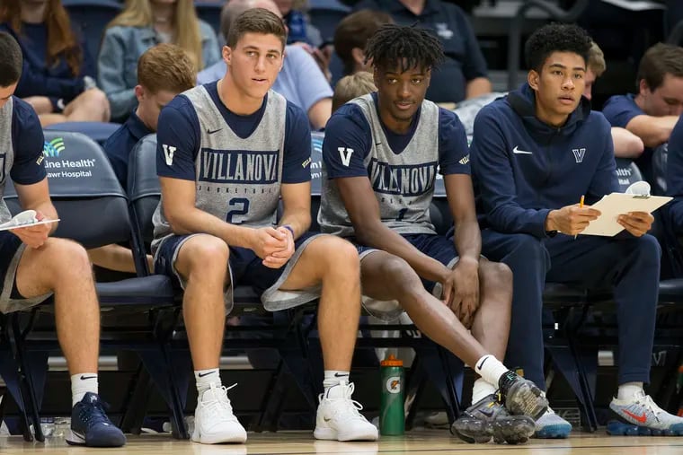 Collin Gillespie, left, and Bryan Antoine, center, are shown on the bench in Villanova’s Blue White Scrimmage on Oct. 10, 2019 at Finneran Pavilion. Antoine has been medically cleared to play and is expected to make his Wildcats debut Thursday at the Myrtle Beach Invitational.