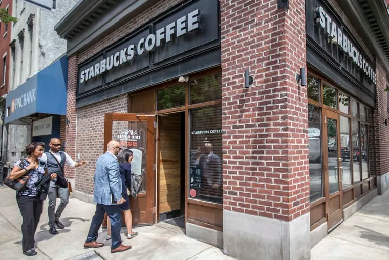 A racial bias training team enters the front door of the Starbucks at 18th and Spruce Streets in 2018.