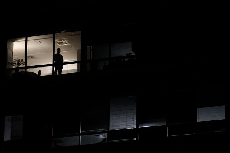 From an adjacent office building, a person watches the scene on Independence Mall prior to the presidential debate at the National Constitution Center.