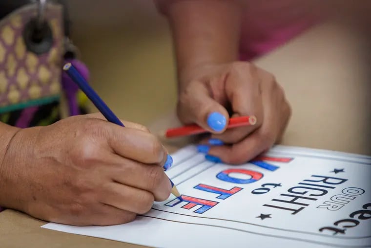 Susan Samuels colors in posters during a volunteer service project on voting rights at the 29th annual Greater Philadelphia Martin Luther King Day of Service held at Girard College.