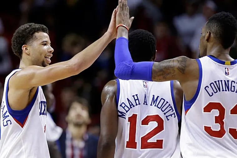Philadelphia 76ers guard Michael Carter-Williams, left, high-fives forward Robert Covington (33) during the second half of an NBA basketball game against the Miami Heat, Tuesday, Dec. 23, 2014, in Miami. The 76ers defeated the Heat 91-87. (Lynne Sladky/AP)