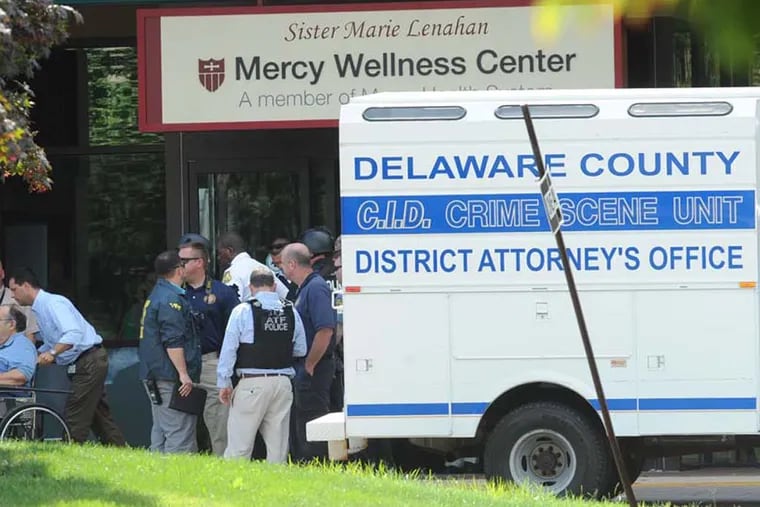 A patient leaves the Mercy wellness center after a shooting incident that left a woman dead and two men wounded. ( CLEM MURRAY / Staff Photographer )