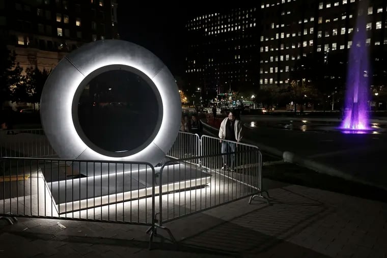 Visitors look over a Portals art installation, which features live streaming video between two international locations, in Philadelphia’s Love Park on Friday, October 18, 2024. The installation did not appear to be complete.