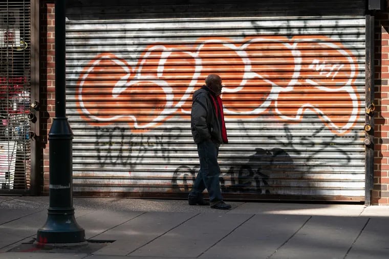 A man walks past a closed business on Chestnut Street, in Philadelphia, April 6, 2020.