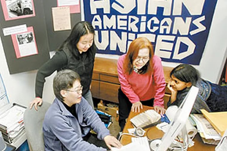 At the office of Asian Americans United, director Ellen Somekawa (left) meets with (from left) Judy Ha, Betty Lui, and Neeta Patel. (Charles Fox / Staff Photographer)